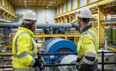 woman and man workers look at gas turbine