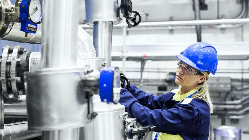 Female engineer releasing a valve at a nuclear plant in OKG, Sweden