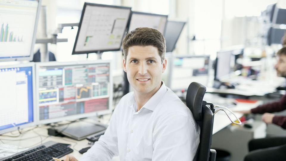 Uniper employee sitting in front of computer monitors in the office in Düsseldorf