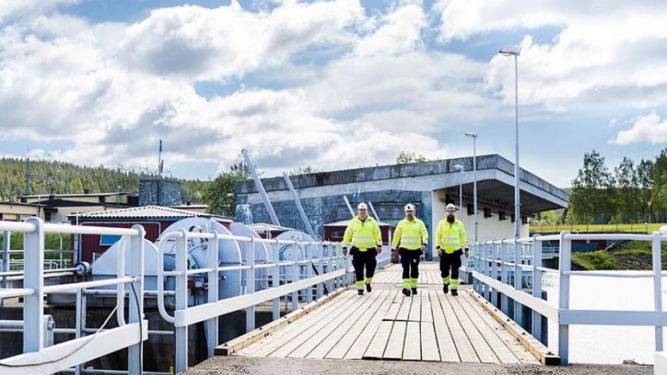 Three engineers walking across a platform at a Hydro plant in Sweden