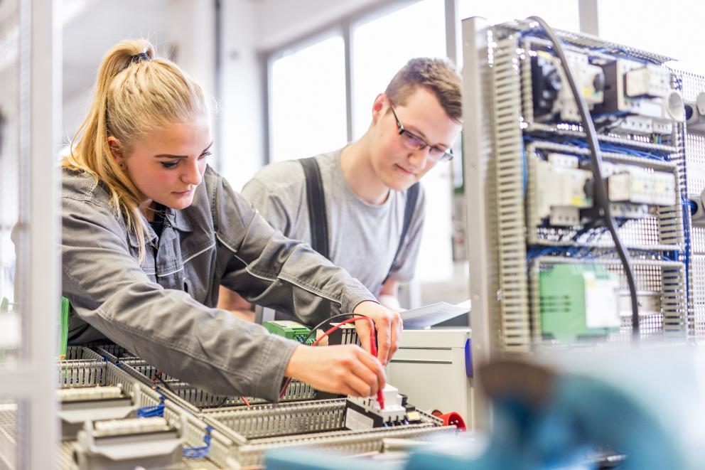 Uniper Auszubildender und Auszubildende arbeiten in Werkstatt an Elektronikteil